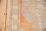 Distressed Oushak rug detail showing even wear, exposed foundation, and pale terracotta, blue.