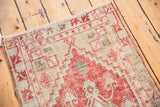 Distressed cherry red geometric pattern and textured ivory pile of a vintage Oushak rug.