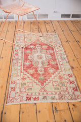 Distressed Oushak runner's end, featuring cherry red and ivory serrated shrub motif in stepped borders.