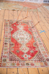 Decorative distressed Oushak rug with geometric floral border and light ivory fringe.