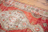 Faded cherry red and ivory geometric patterns with light etching on vintage Oushak rug.