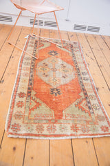 Distressed Oushak runner with faded brick red field, primitive germinating plants, and vine border.