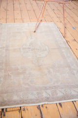 Faded beige and brown border with distressed texture on a vintage Oushak rug.