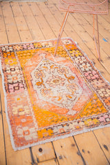 Distressed lower corner detail showing orange and blush curvilinear border, with fringe.