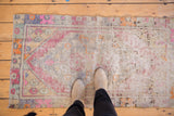 Vintage distressed Oushak rug surface, revealing hard wear and muted pink, purple, blue hues.