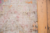 Distressed vintage Oushak rug texture, showing worn pile in ivory, pink, and light orange.