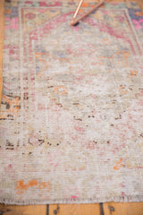Vintage distressed Oushak rug's worn pile, revealing soft pink, platinum, and pale slate blue.