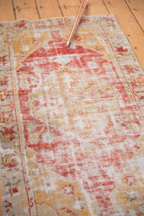 Distressed vintage Oushak rug runner showing faded red and saffron yellow with visible foundation.