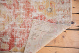 Distressed red and saffron pile of vintage Oushak runner, revealing its hand-knotted foundation.