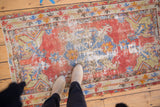 Distressed red and blue Oushak rug with prominent wear, showing central medallion and sprawling leaves.