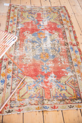 Distressed vintage Oushak rug with etching to silver shades, cinnabar red, and slate blue.