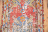 Distressed vintage Turkish Oushak rug runner detail, showing worn cinnabar red field, blue motifs, and exposed foundation.