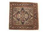 A square antique Farahan Sarouk bag face with a dark navy palmette medallion over an open ivory field.