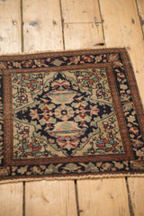 High-angle view of a low-pile antique Farahan Sarouk bag face with a floral medallion.