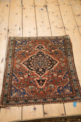 Vintage Persian Farahan Sarouk rug corner: brick red field, navy scalloped medallion, floral motifs.