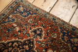 Vintage Farahan Sarouk rug corner, with brick red field, blossoming buds, and blue border.