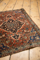Border detail and brick red field with navy blue floral patterns on the Farahan Sarouk rug.