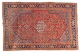 Antique Persian Bijar rug with a cherry red Herati field, central ivory medallion, and a deep navy blue border.
