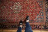 The low, dense pile and detailed Herati motif of a collector's antique Persian Bijar rug.