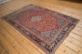 Angled view of an antique Persian Bijar rug showing its balanced composition and traditional Herati motif.