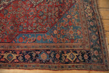 Intricate corner of an antique Persian Bijar rug showing the Herati field, blue spandrel and navy border.