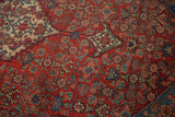 Angled view of the classic Herati motif on the cherry red field of an antique Persian Bijar rug.