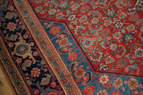 Layered borders in navy and sky blue alongside the Herati motif field of an antique Bijar rug.