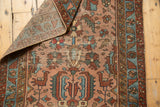 Folded corner of antique Lilihan runner showing hand-knotted weave, worn rose field, and bird motifs.