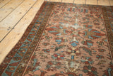 Dusty blush field of an antique Lilihan runner, featuring worn floral bouquets, geometric motifs, and visible pile etching.