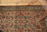 Persian Lilihan rug's rose field with geometric floral motifs, birds, serpents, and teal-blue border.
