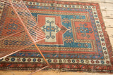 Antique Caucasian Farchalou Kazak style rug corner with geometric borders, madder red and teal, worn edge.