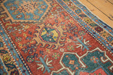 Antique Heriz runner detail: geometric pattern, cherry red field, mallard green, camel tones, low pile.