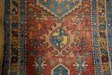 Antique Heriz rug runner with saturated geometric medallion, mallard green, saffron yellow, and low pile.