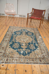 Distressed Turkish Oushak rug corner, sky blue field, beige arabesques, and textured pile.