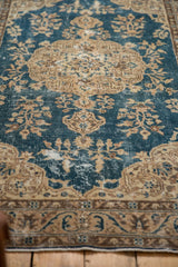 Decorative distressed blue and beige Oushak rug with low pile and floral motifs.