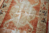 Distressed Oushak runner with faded cherry red, ivory diamond motif and visible foundation.