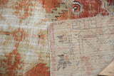 Distressed Oushak rug pile in brick red and ivory with exposed foundation.