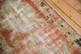 Distressed Oushak runner pile, brick red, antique ivory tones, with foundation showing.