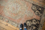 Distressed vintage Oushak runner with blush, ivory, and charcoal octagonal motif, worn texture, and feet for scale.