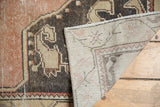 Vintage distressed Oushak rug showing hand-knotted foundation and worn dusty rose pile.