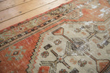 Distressed vintage Oushak runner detail showing geometric patterns on a worn beige field with faded brick red.