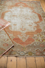 Serrated medallion with even wear and abrashes on a distressed Oushak rug, rust and beige.