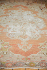 Distressed Oushak rug texture, highlighting low pile with rust, terra cotta, and ivory hues.
