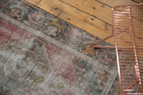 Distressed Oushak runner pile with faded blush, oxidized silver, and gold hues.