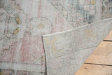 Worn pile of vintage Oushak rug in blush, ivory, gold, revealing hand-knotted foundation.