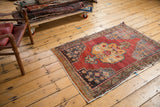 Distressed Turkish Oushak rug with black cherry red field and stepped slate blue floral spandrel.