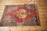 Faded floral motifs on the lower right corner of a vintage distressed Oushak rug.
