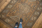 Distressed vintage Melas rug field with geometric floral patterns and muted earthy tones.