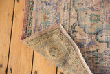 Distressed pile, hand-knotted foundation, and tied fringe on this vintage Turkish Oushak corner.