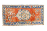 Distressed vintage Oushak rug runner with vibrant orange-red field, sky blue borders, and ivory floral medallion.